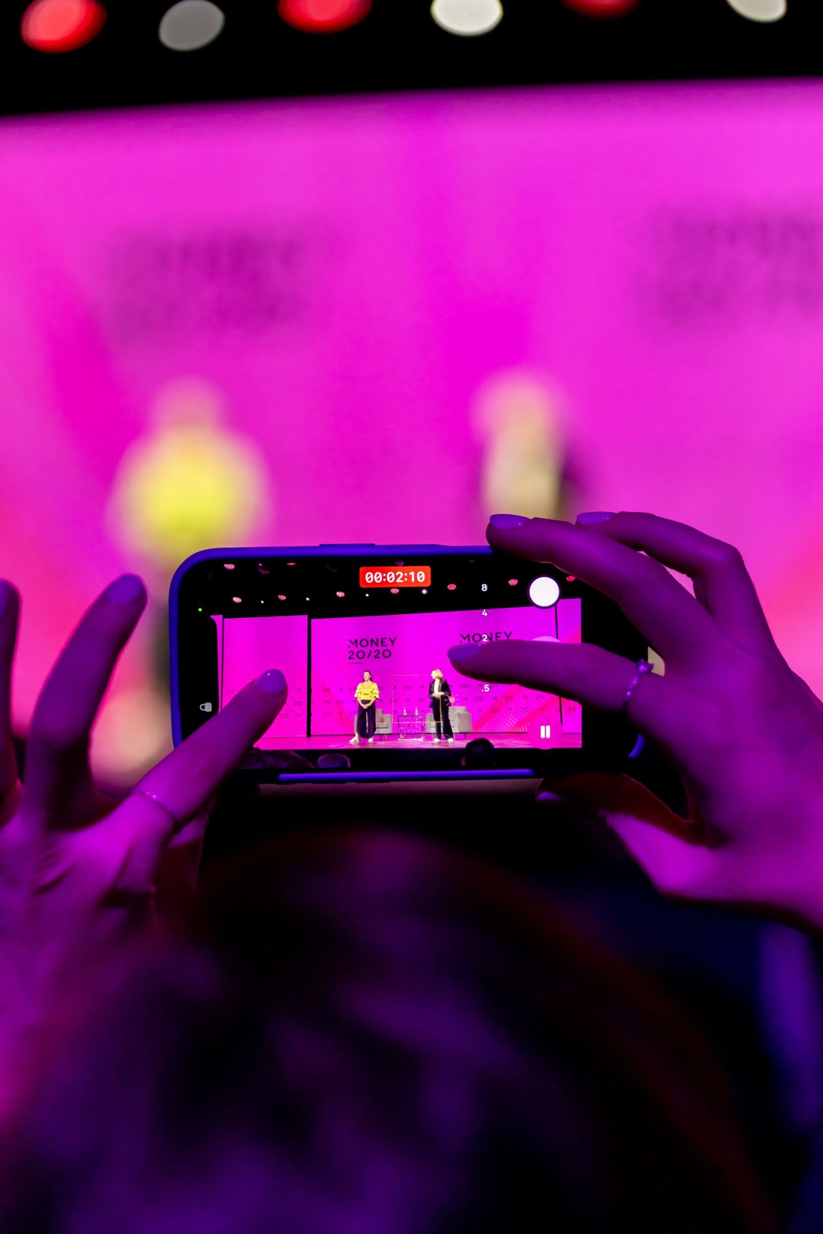 An attendee filming the Money 20/20 mainstage on a phone