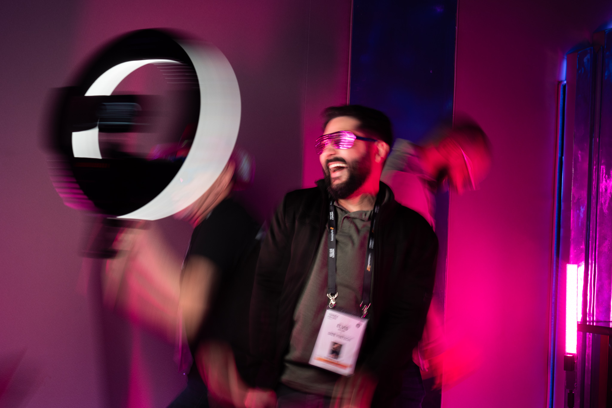 Attendee laughing in LED shutter glasses inside a purple activation
